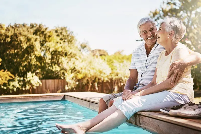 Retired couple sits by pool